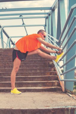 Genç adam bir çit koşu sonra germe / excercising.