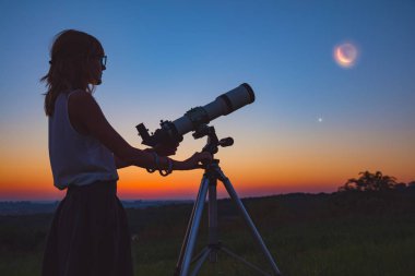 Kız ay tutulması bir teleskopla. Benim astronomi çalışmaları.