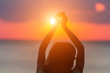 Hava ve okyanus sahne elinde bir kızla silüeti.