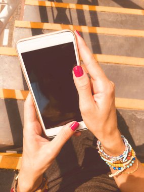 Cep telefonu kullanan kadın / kentsel bir ortamda merdivenlerde otururken smartphone.