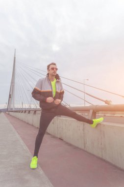 Kentsel jogger bir köprüde germe.