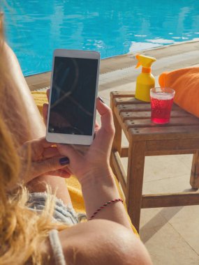 Cep telefonu yüzme havuzu kullanan kız.