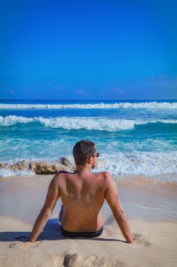 Yalan ve tropikal bir kumsalda zevk adam.