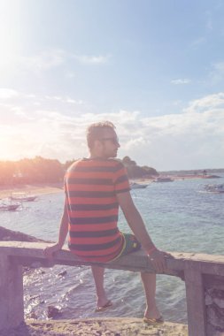 Tropik bir adada okyanusun defne bakıyorsun adam.