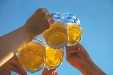 Bir grup genç insan açık havada bira ile zevk.