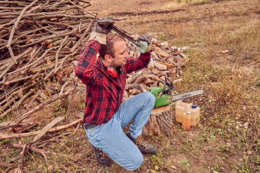 Testere ile kesme woods yığını ile oduncu.