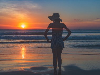 Günbatımı bir kız silüeti / gündoğumu zaman okyanusun içinde.