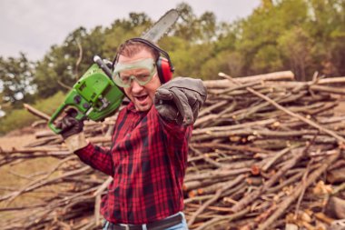 Testere ile kesme woods yığını ile oduncu.