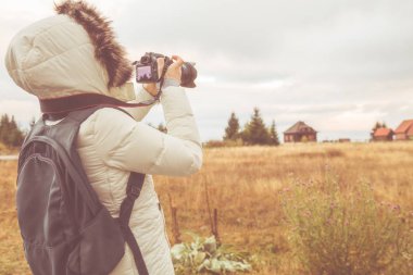 Dağda dijital SLR kullanan kadın / banliyösü çevresi.