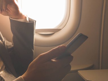 Uçağın içinde Smartphone kullanan adam.