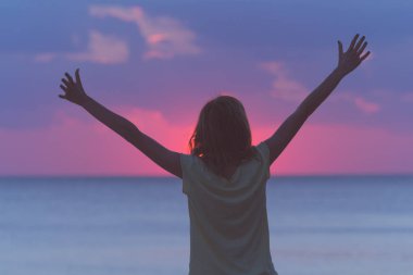 Hava ve okyanus sahne elinde bir kızla silüeti.