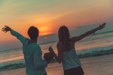 Okyanus Bali, Endonezya gün batımını izlerken cocnut suyu içme çift.
