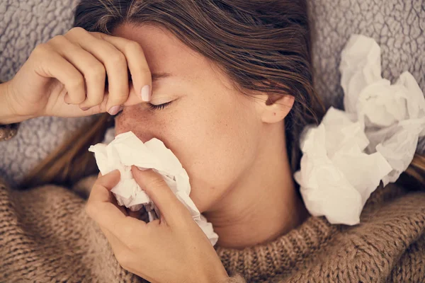 Sick woman with seasonal infections, flu, allergy lying in bed.