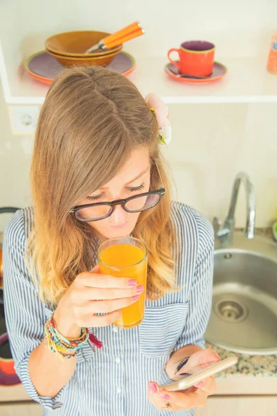 Ragazza Carina Bere Succo Arancia Fresco Utilizzando Cellulare Cucina — Foto Stock