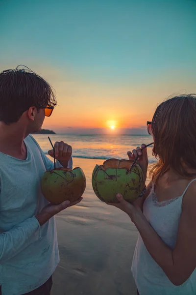 Casal Beber Suco Coco Enquanto Assiste Pôr Sol Sobre Oceano — Fotografia de Stock