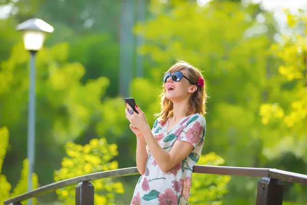 Χαρούμενο Κορίτσι Που Χρησιμοποιούν Κινητό Τηλέφωνο Μια Όμορφη Καλοκαιρινή Μέρα — Φωτογραφία Αρχείου
