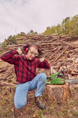 Testere ile kesme woods yığını ile oduncu.