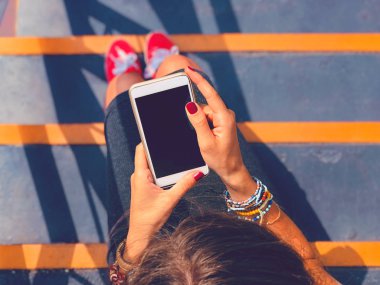 Cep telefonu kullanan kadın / kentsel bir ortamda merdivenlerde otururken smartphone.