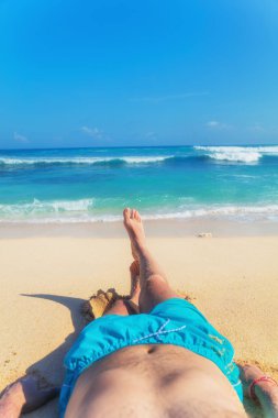 Yalan ve tropikal bir kumsalda zevk adam.