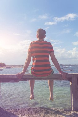 Tropik bir adada okyanusun defne bakıyorsun adam.