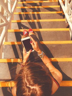 Cep telefonu kullanan kadın / kentsel bir ortamda merdivenlerde otururken smartphone.