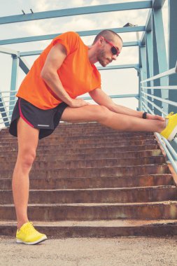 Genç adam bir çit koşu sonra germe / excercising.