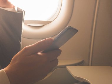 Uçağın içinde Smartphone kullanan adam.