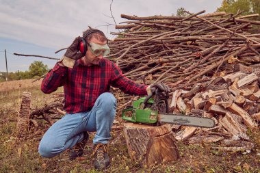 Testere ile kesme woods yığını ile oduncu.