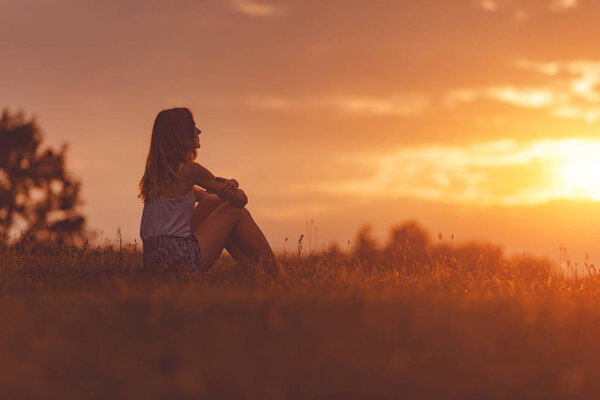 Девушка наслаждается на лугу на золотом закате
.