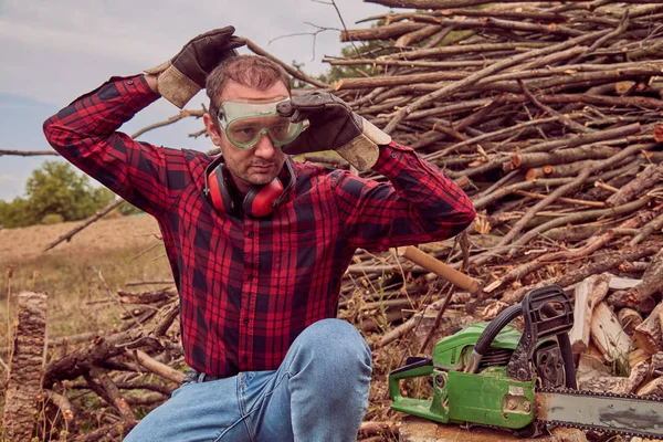 Testere ile kesme woods yığını ile oduncu.