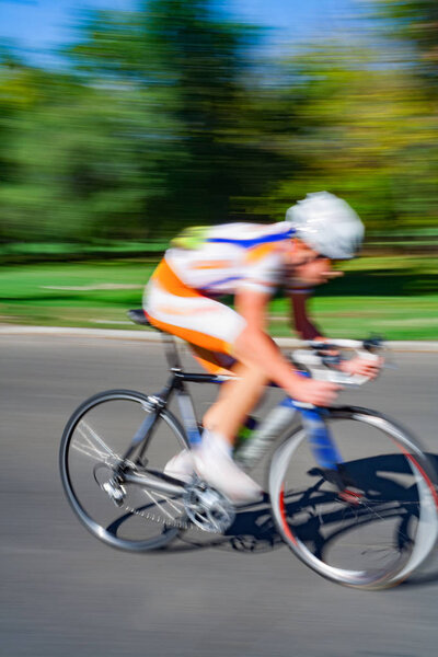 Racing bicycle in blurred motion speeding down the road.