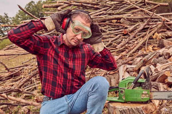 Testere ile kesme woods yığını ile oduncu.