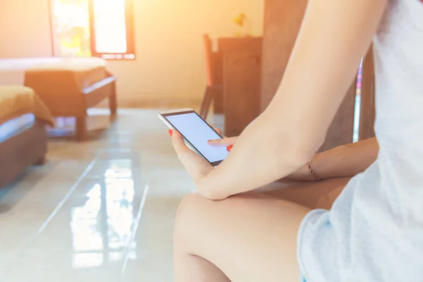 Woman using smart phone in the house.