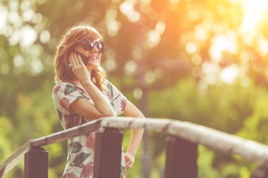 Bir güzel yaz günü cep telefonu kullanan neşeli kız.