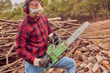 Testere ile kesme woods yığını ile oduncu.