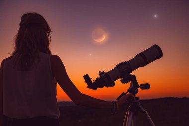 Kız ay tutulması bir teleskopla. Benim astronomi çalışmaları.