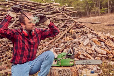 Testere ile kesme woods yığını ile oduncu.