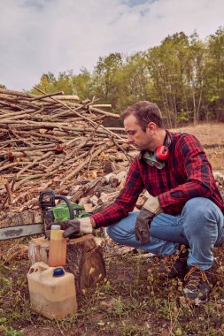 Testere ile kesme woods yığını ile oduncu.