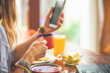 Evin içinde cep telefonu kullanarak ve kahve içme kadın / çay.