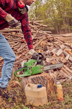 Testere ile kesme woods yığını ile oduncu.