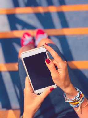 Cep telefonu kullanan kadın / kentsel bir ortamda merdivenlerde otururken smartphone.