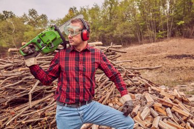 Testere ile kesme woods yığını ile oduncu.