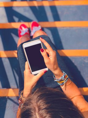 Cep telefonu kullanan kadın / kentsel bir ortamda merdivenlerde otururken smartphone.