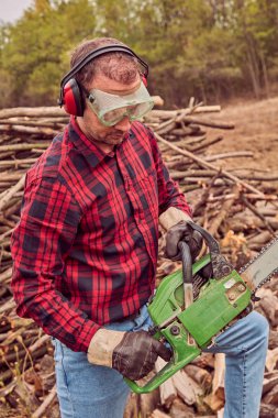 Testere ile kesme woods yığını ile oduncu.