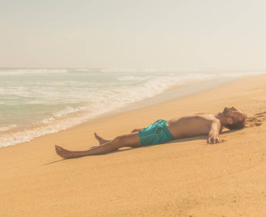 Yalan ve tropikal bir kumsalda zevk adam.