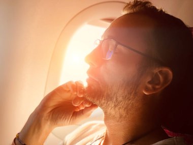 Yorgun adam uçak koltuğunda uyuyan.