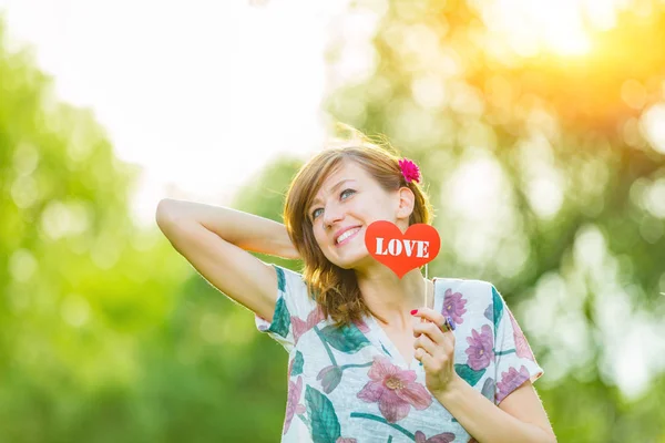 Cute Young Woman Holding Paper Heart Shaped Sign Outdoors — Stock Photo, Image