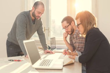 Güneşli bir ofiste Genç Mimarlar grubu.