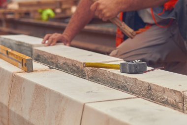 Beton bloklar tesviye teyp ölçme ile gerçek inşaat işçisi.