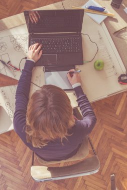 Parlak güneşli oda bir projede çalışan kadın mimar.